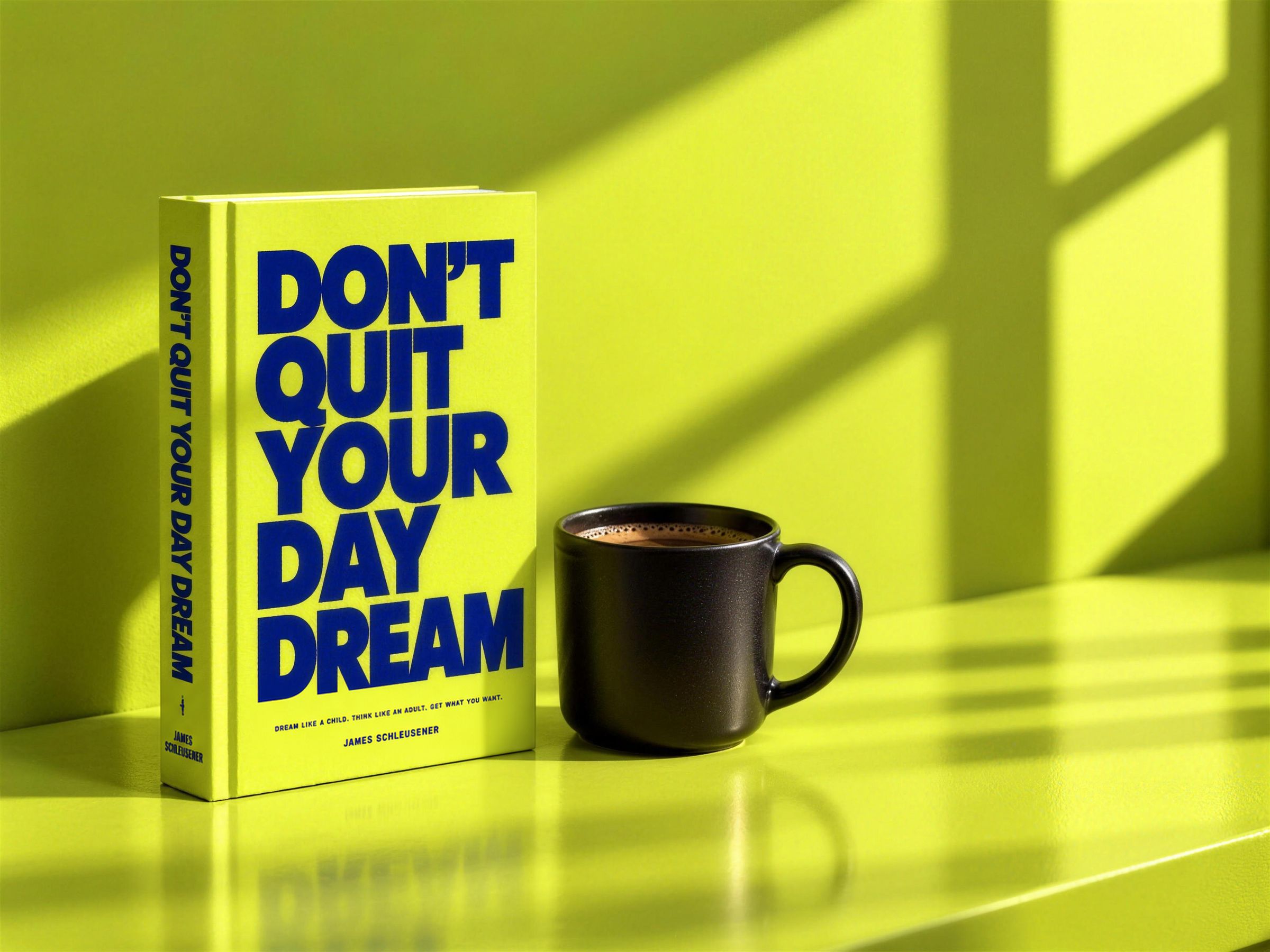 Don't Quit Your Daydream, a lime hardback with electric blue type, standing on a sunlit lime shelf next to a black mug of coffee