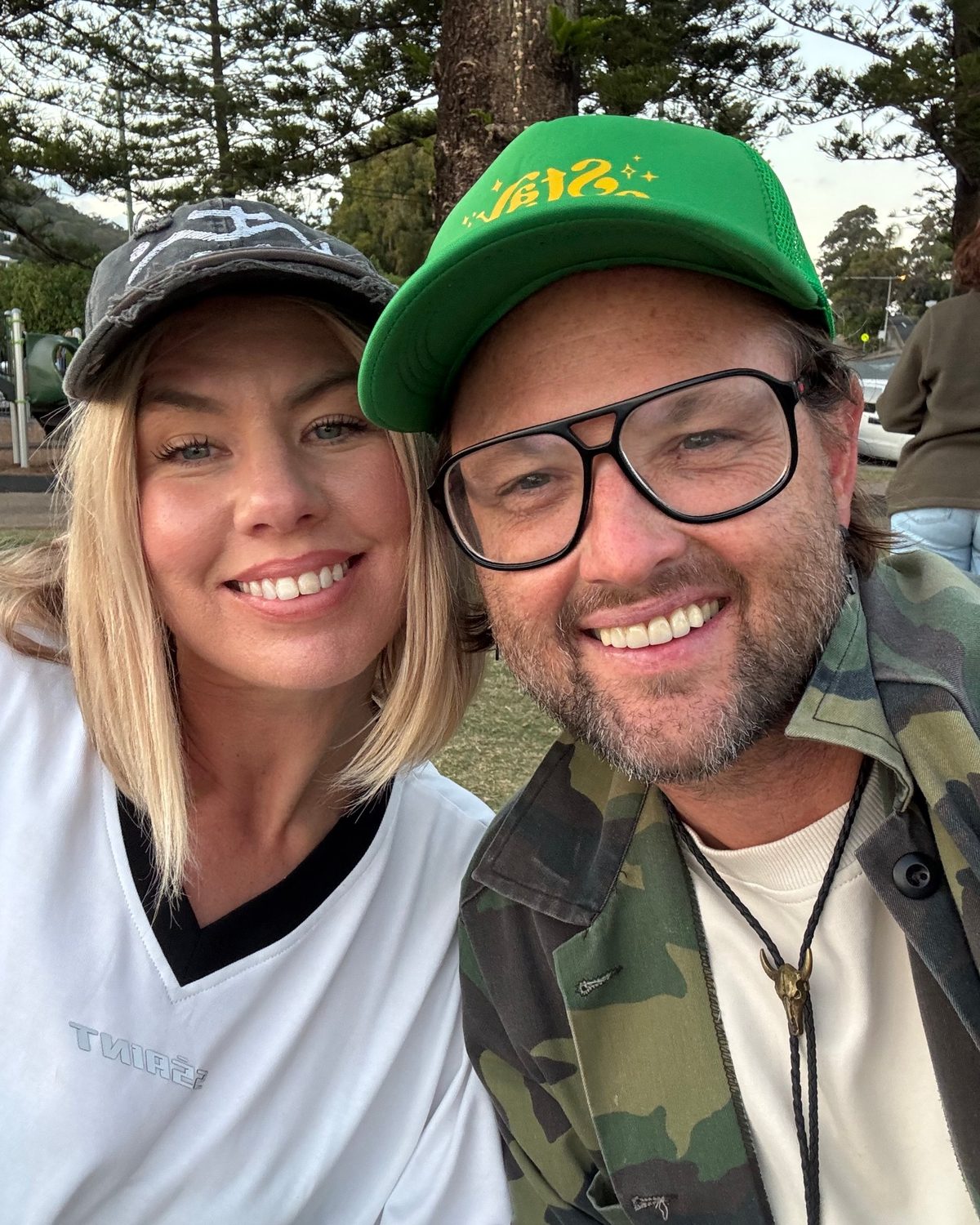 Jimmi and his wife, grinning in a park at dusk